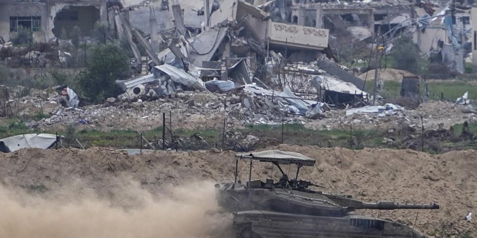 Un tanque de las Fuerzas de Defensa Israelí avanza frente a edificios destruidos en Gaza, ayer.