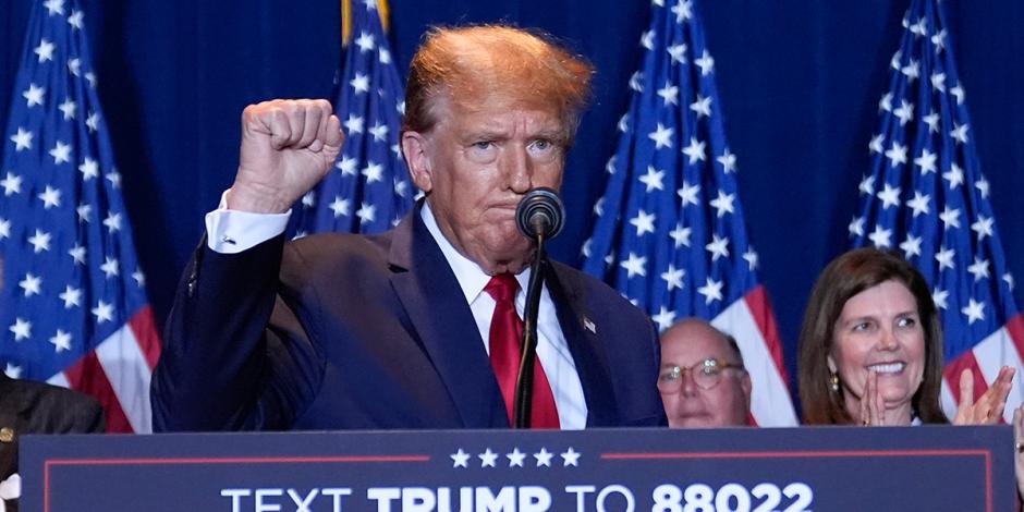 El precandidato presidencial republicano y expresidente Donald Trump alza un puño durante un evento en la noche de las primarias en la feria estatal de Carolina del Sur, el sábado 24 de febrero de 2024