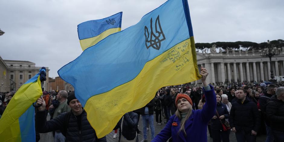 Fieles católicos ondean una bandera ucraniana en la Santa Sede, ayer, tras el mensaje del Papa en torno a la guerra.