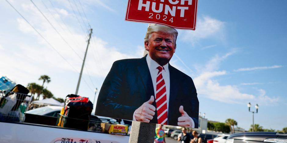 Simpatizantes de Donald Trump colocan carteles alusivos al exmandatario en calles de Florida, ayer.