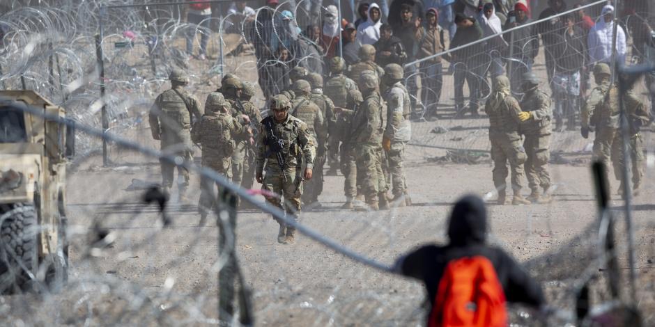 Una persona observa la reja tendida tras el forcejeo entre migrantes y soldados en Texas, ayer.