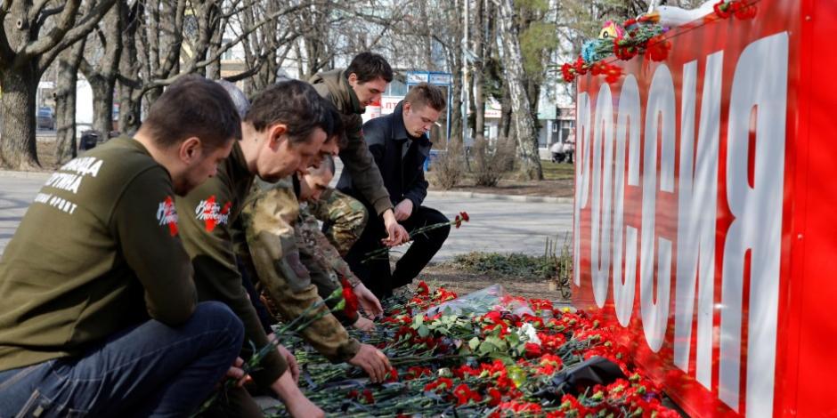Ciudadanos rusos dejan flores en un monumento en honor a las víctimas del atentado en Moscú.