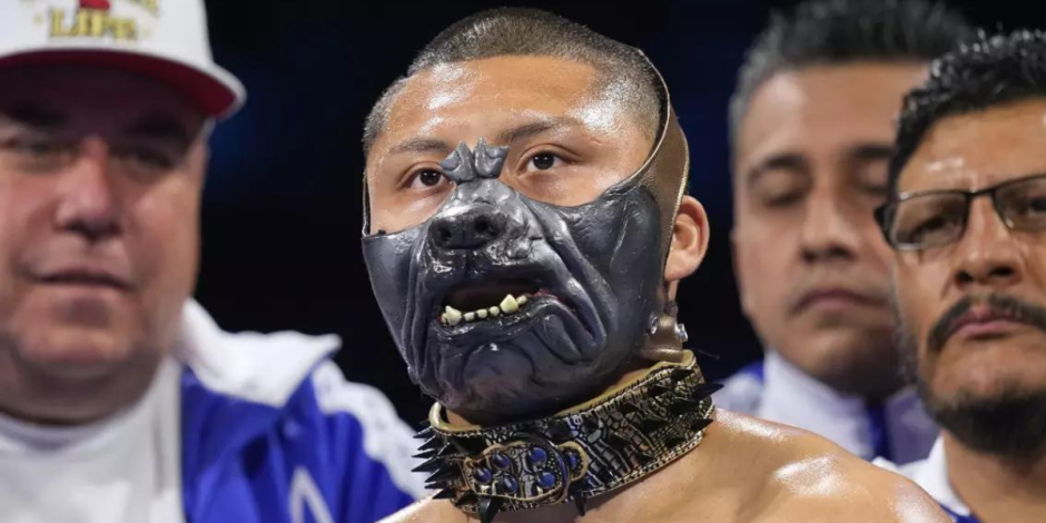 Isaac Cruz usa una máscara al ingresar al ring para un combate de boxeo de pesos ligeros contra Francisco Vargas