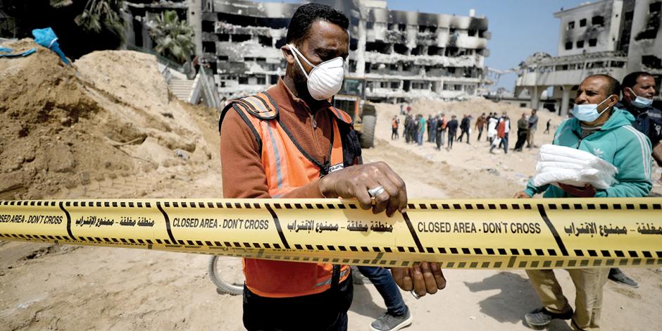 Voluntarios palestinos realizan labores en una presunta fosa común cerca de un hospital en Gaza.