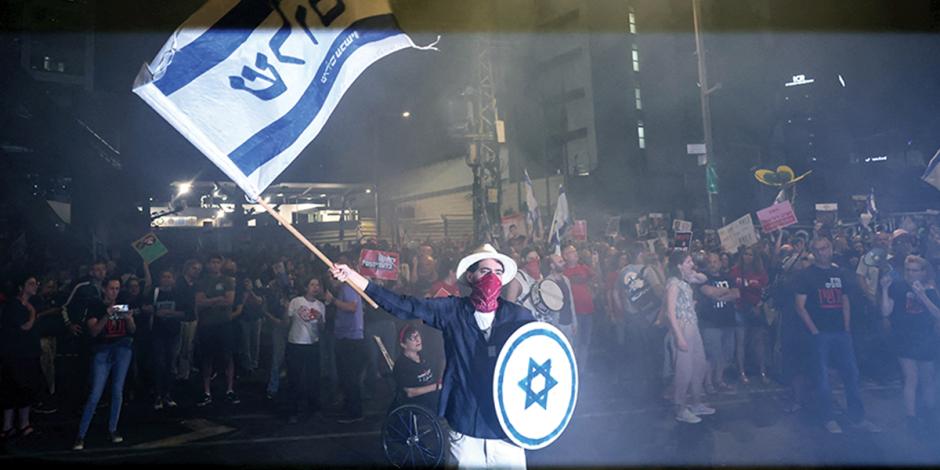 Residente israelí ondea una bandera para exigir el retorno de rehenes, ayer.