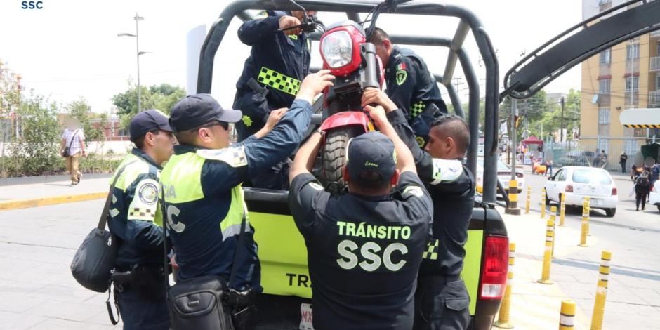 Elementos de Tránsito suben una moto a una camioneta, ayer.
