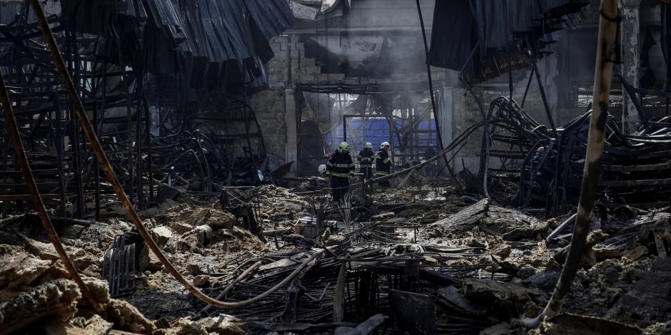Bomberos revisan los daños tras el bombardeo contra una tienda en Járkov, ayer.