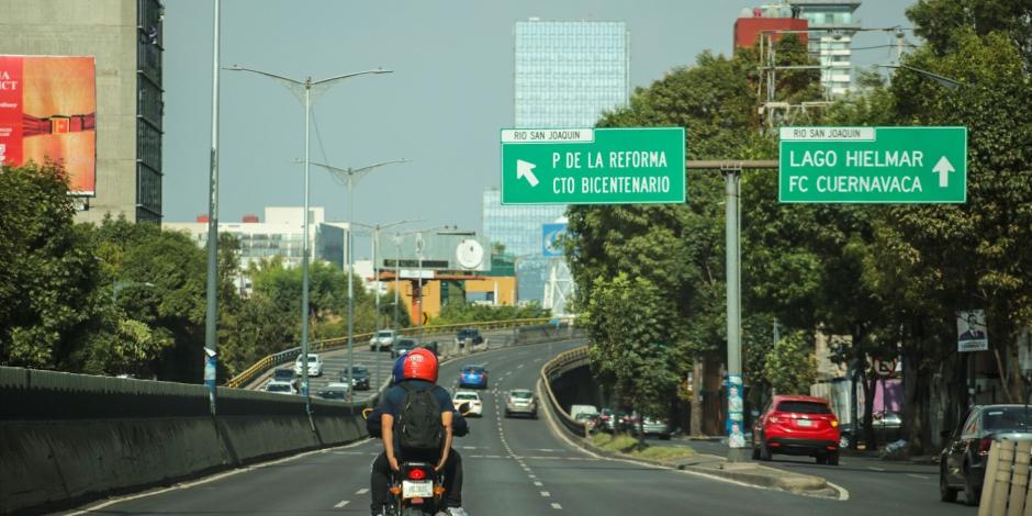 Motociclistas y automovilistas circulan sobre una vialidad de la CDMX, ayer.