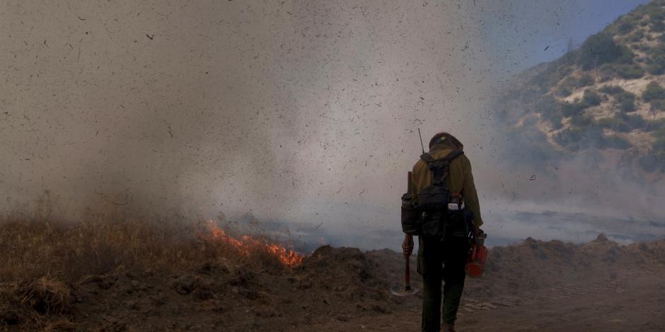 Un bombero se une a la lucha para combatir con un incendio al norte de Los Ángeles.
