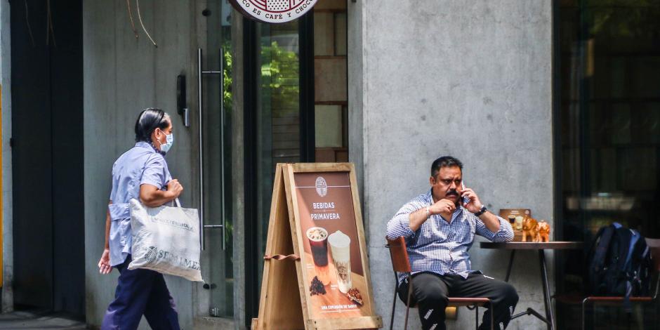 Un hombre habla por teléfono mientras espera en un café.