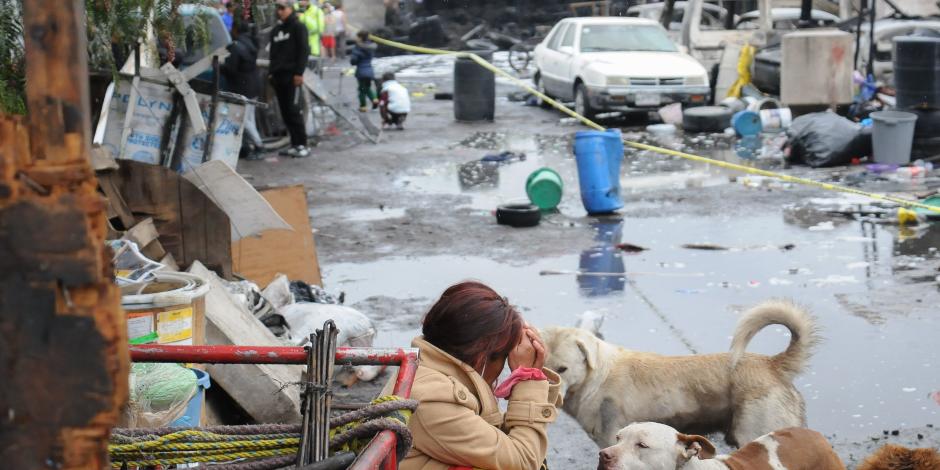 Una mujer observa los restos de las viviendas consumidas por las llamas, ayer.