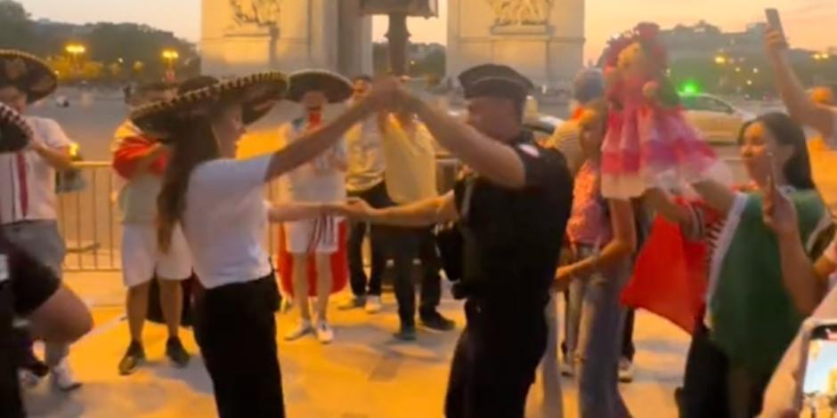 Una mexicana sacó a bailar a un policía francés frente al Arco del Triunfo.