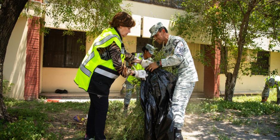 Elementos de la Guardia Nacional realizan labores de deshierbe en la Secundaria Número 38.