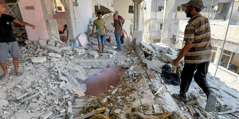 Palestinos inspeccionan el lugar de un ataque israelí en la ciudad de Gaza, ayer.