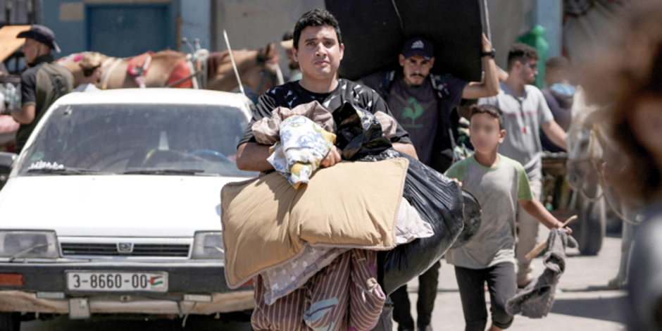 Palestinos evacuan una escuela-refugio en Deir al-Balah, Gaza, ayer.