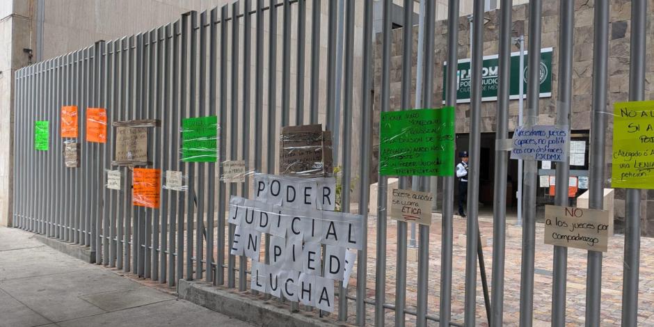 Cartulinas con consignas pegadas en la reja de los tribunales laborales, ayer.