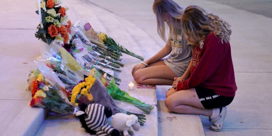 Dos alumnas de la secundaria Apalachee colocan una ofrenda en las escaleras de la escuela en honor a las víctimas del tiroteo de ayer.