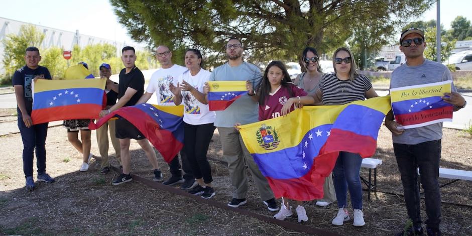 Disidentes refugiados en España expresan su apoyo al líder opositor con banderas de Venezuela, ayer, afuera de la Base Aérea Militar de Torrejón.