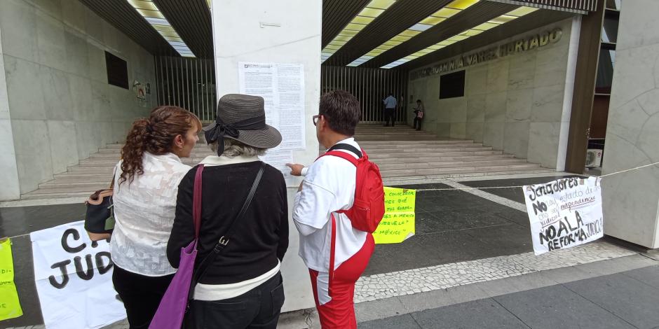 Tres mujeres leen un pliego de trabajadores del PJCDMX, ayer.