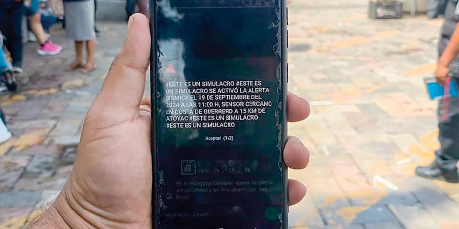 Un hombre muestra el mensaje que le llegó a su teléfono celular, ayer, durante el simulacro en la Ciuda de México.