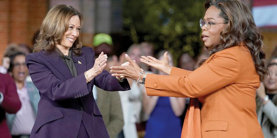 La aspirante demócrata, Kamala Harris (de traje morado), saluda a la presentadora Oprah Winfrey.