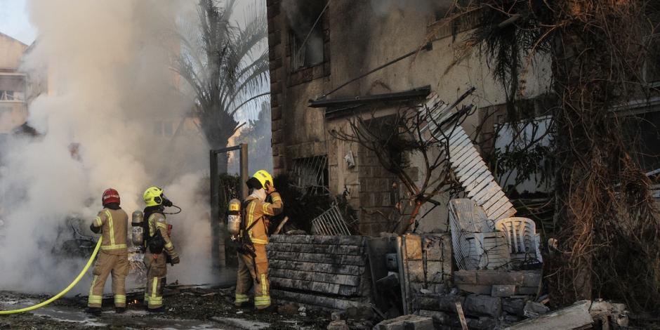 Personal de seguridad israelí atiende incendios de casas en el norte del país tras lanzamientos de cohetes desde Líbano, ayer.