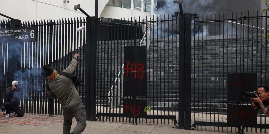 Uno de los embozados lanza un explosivo a la sede del Senado de la República, ayer.