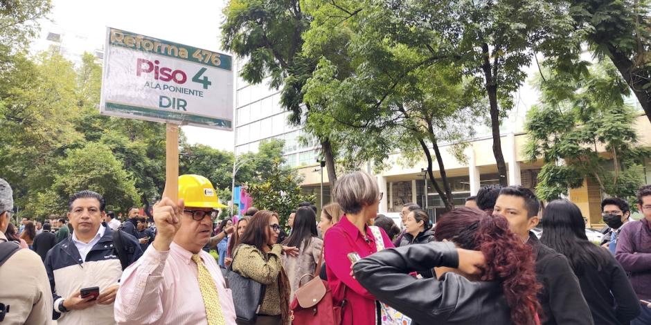 Trabajadores, durante la evacuación de un inmueble en Reforma, ayer.