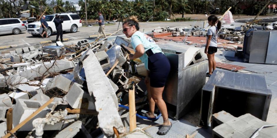 Una mujer en Florida, parada sobre los escombros que dejó el paso del huracán Helene.