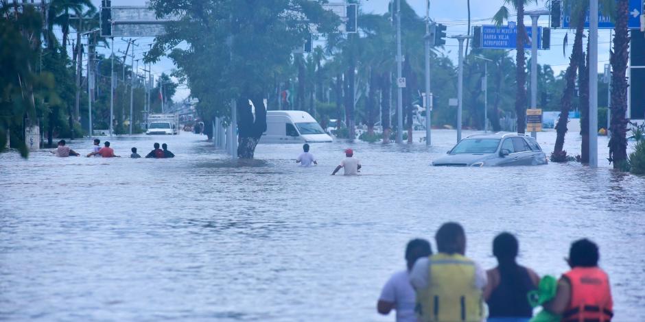 Habitantes caminan entre las calles inundadas, buscando alimentos o en busca desalojar la zona.