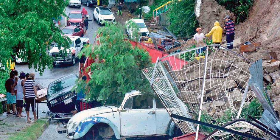 Autos quedaron aplastados por el derrumbe de cerros, otros más fueron llevados por la corriente, ayer.