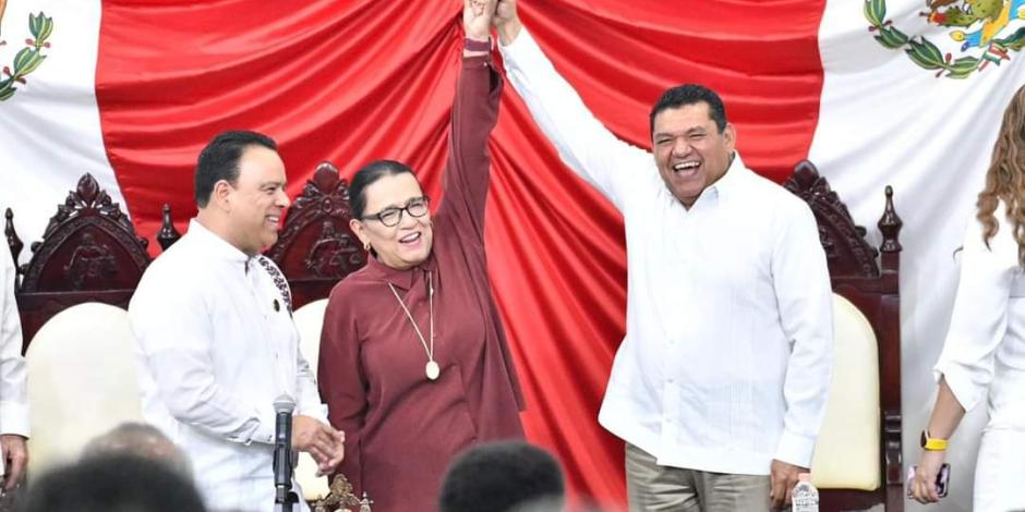 Rosa Icela Rodríguez, hasta ayer secretaria de Seguridad, levanta la mano a Javier May luego de su toma de protesta como gobernador de Tabasco.