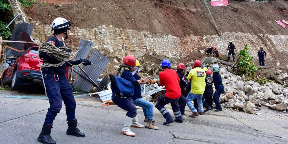 Rescatistas trabajaron en una unidad habitacional afectada por deslaves, ayer.