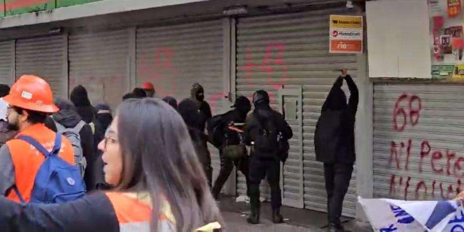 Bloque negro realiza destrozos y pintas en negocios durante marcha del 2 de octubre.