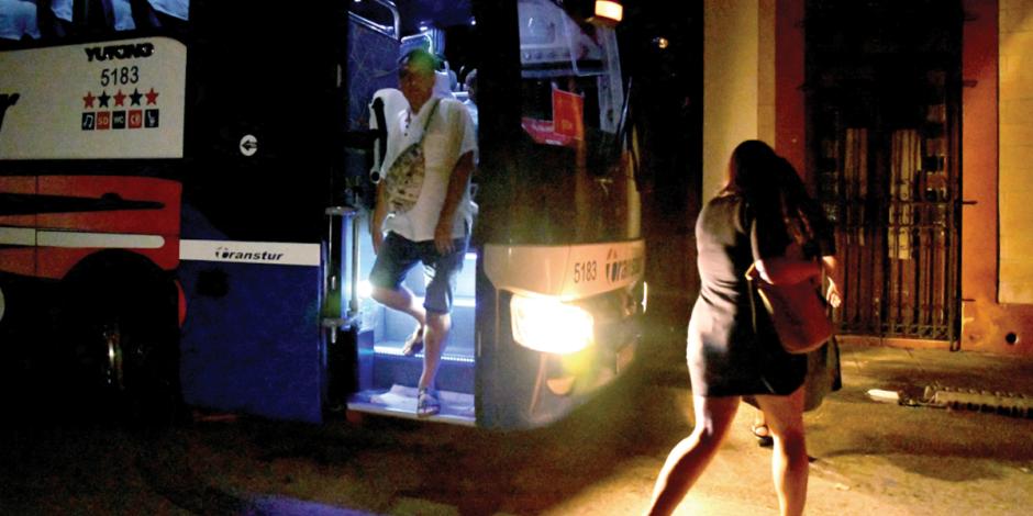 Turistas descienden de un autobús en medio del apagón en las calles de La Habana, la noche de ayer.