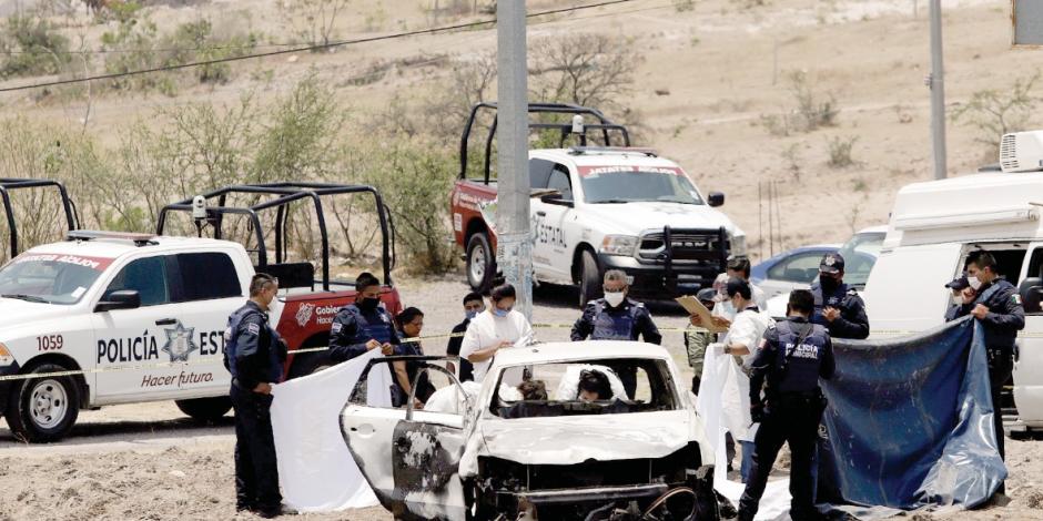 Policías de Puebla y peritos atienden el linchamiento de dos personas en Los Ángeles Tetela, en mayo de 2020.