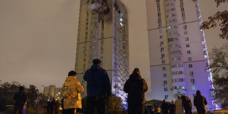 En Kiev observan el fuego en un edificio tras el ataque de un dron ruso, ayer.