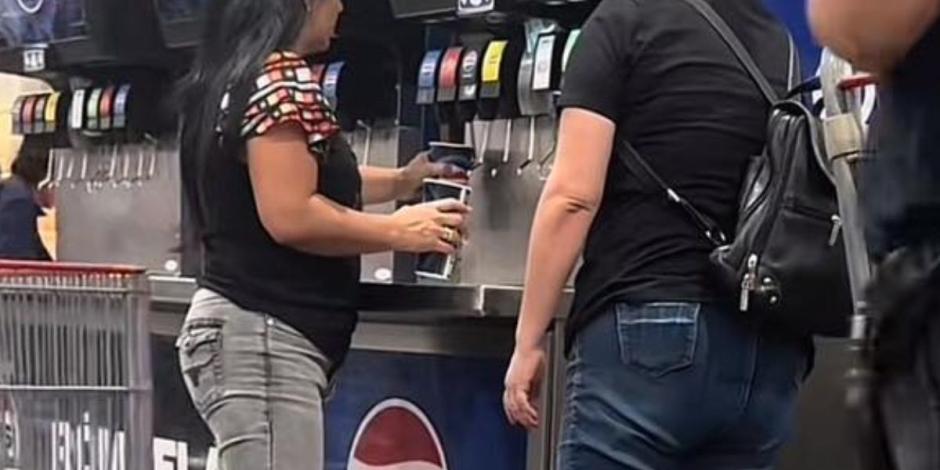 mujeres se llevan el refresco de una máquina del Costco.