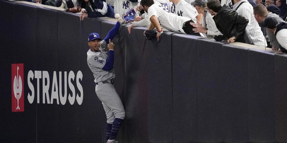 Dos fans de los Yankees pelean con Mookie Betts para quitarle una pelota en la Serie Mundial.