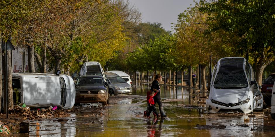 Personas cruzan la calle después de las inundaciones en Utiel, España.