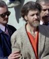 Theodore "Ted" Kaczynski es escoltado a su auto afuera de una corte federal en Helena, Montana, el 4 de abril de 1996