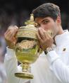 Carlos Alcaraz besa el trofeo que lo acredita como campeón de Wimbledon 2024.