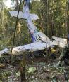 En esta foto proporcionada por la Oficina de Prensa de las Fuerzas Armadas de Colombia, un soldado permanece frente a los restos de una avioneta Cessna C206 el jueves 18 de mayo de 2023. La aeronave se estrelló en la selva de Solano, Colombia. Las autoridades buscaron a cuatro niños indígenas que piensan podrían haber sobrevivido el accidente.