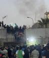 Manifestantes trepan un muro en la embajada sueca de Bagdad, el jueves 20 de julio de 2023. Manifestantes airados por la quema de un ejemplar del Corán irrumpieron en la embajada sueca en Bagdad, donde provocaron un pequeño incendio.