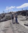 El gobernador Josh Green (izq.) visita una de las zonas devastadas junto al alcalde de Lahaina, Richard Bissen, ayer.