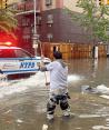 Un trabajador intenta destapar una coladera en medio de las inundaciones en Brooklyn, ayer.