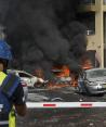 Autos arden después de que un cohete disparado desde la Franja de Gaza impactara en un estacionamiento y un edificio residencial en Ashkelon, sur de Israel