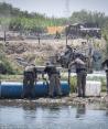 Policías de Texas colocan boyas con alambre de púas a lo largo del río Bravo, en la frontera con México.