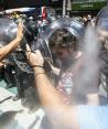 Manifestantes chocan con agentes que los rocían con gas, ayer.