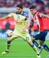 Henry Martín y Víctor Guzmán en la disputa de un balón en la ida de semifinales entre Chivas y América.